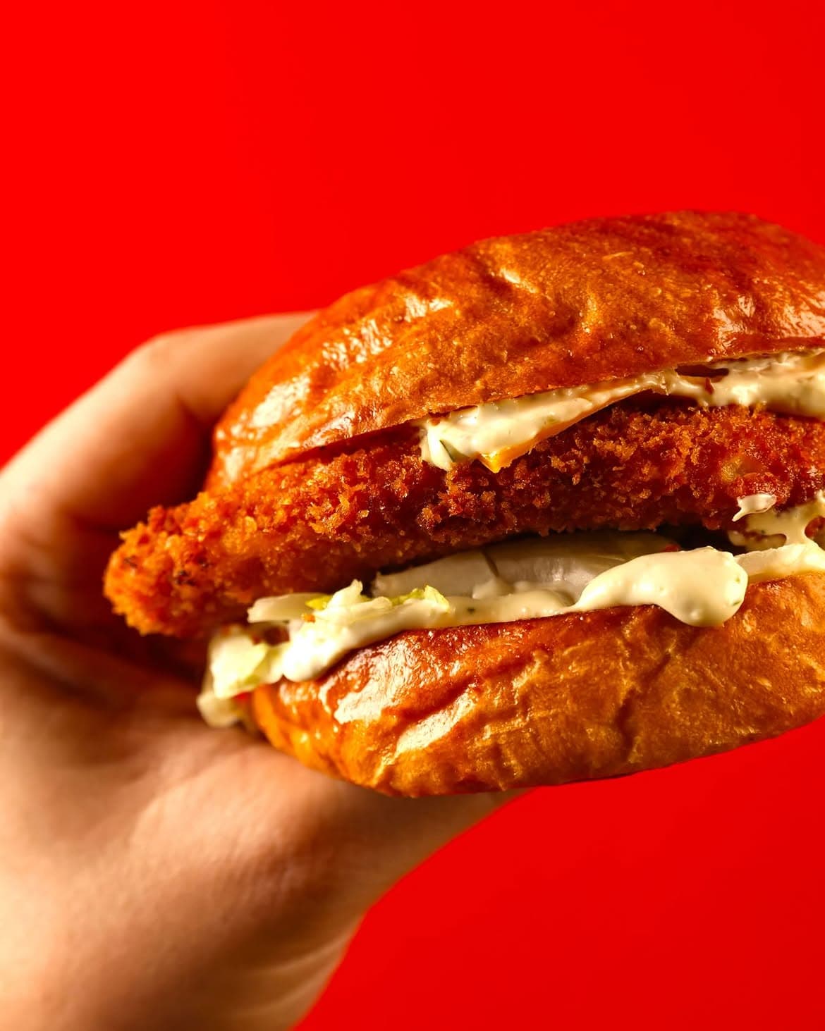Fero crispy chicken burger against a bold red backdrop
